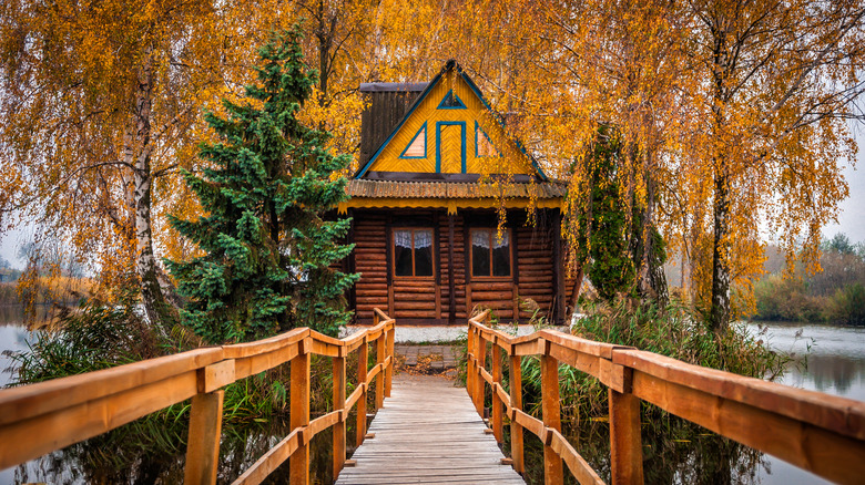 old wooden house on lake autumn