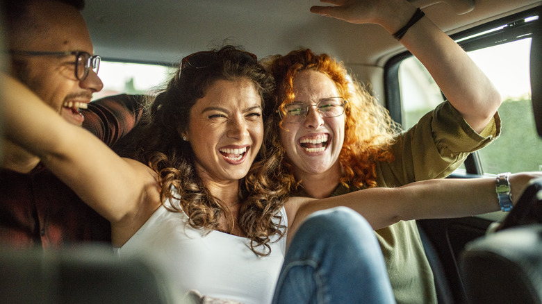 Two women laughing and driving