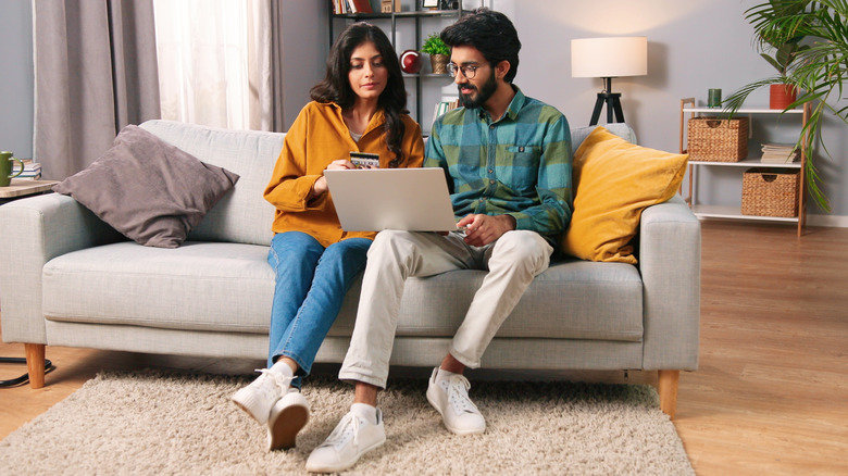 young couple on sofa with laptop
