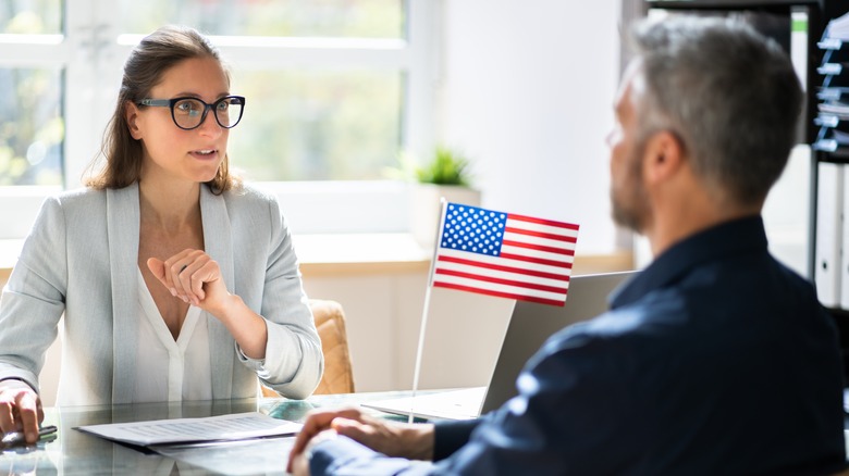 people at desk with U.S. flag